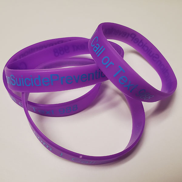 A photo of four purple wristbands available to order as part of a bundle. The visible text reads "SuicidePrevention" and "Call or Text"